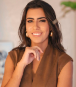 Foto profissional de Amanda Freiria, cirurgiã dentista, em um ambiente clínico, vestida com jaleco, transmitindo confiança e profissionalismo.