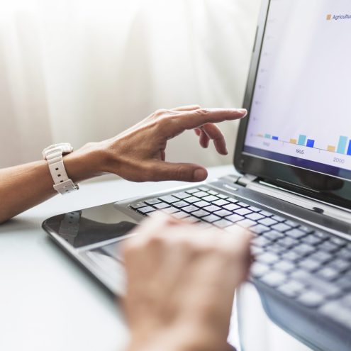 Mão mexendo no notebook, representando o gerenciamento de tráfego pago.